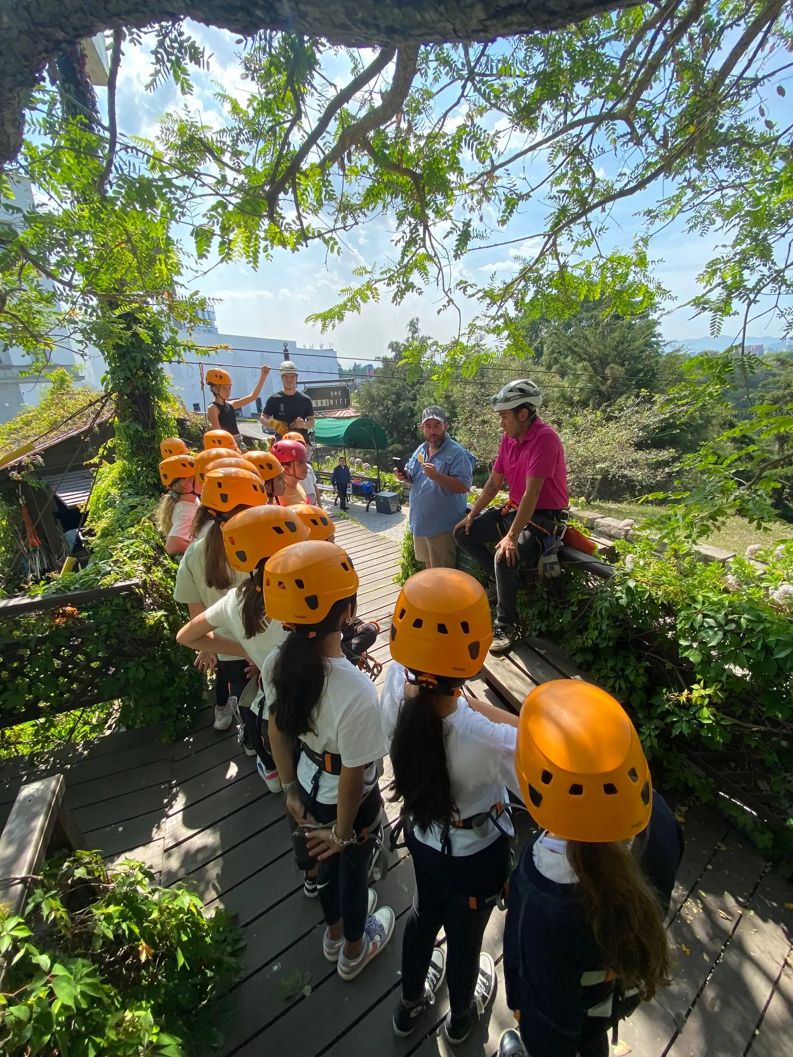 Grupo con cascos y arneses escuchando la charla de seguridad de los instructores antes de volar