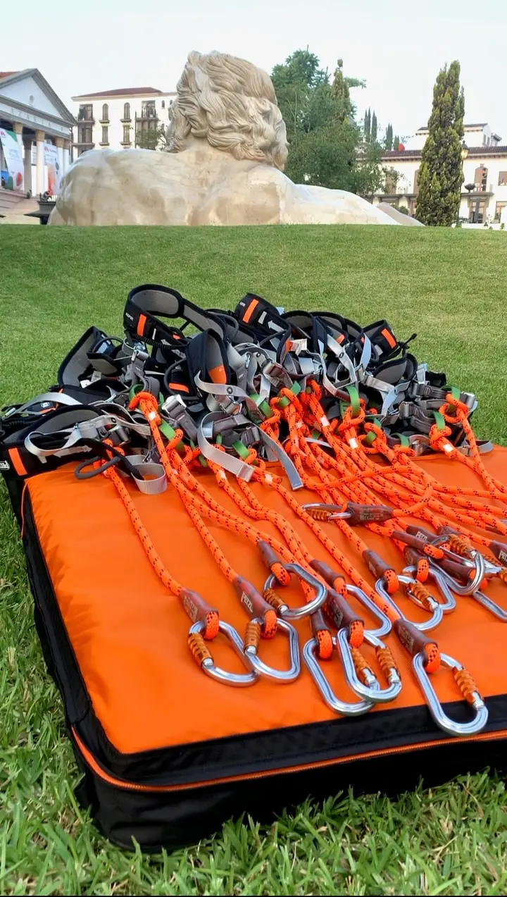Arneses, poleas y mosquetones Petzl listos sobre el césped